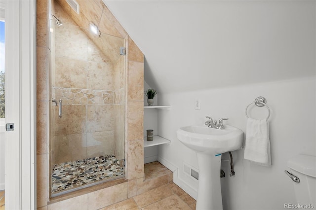 bathroom featuring a shower stall, a sink, and vaulted ceiling