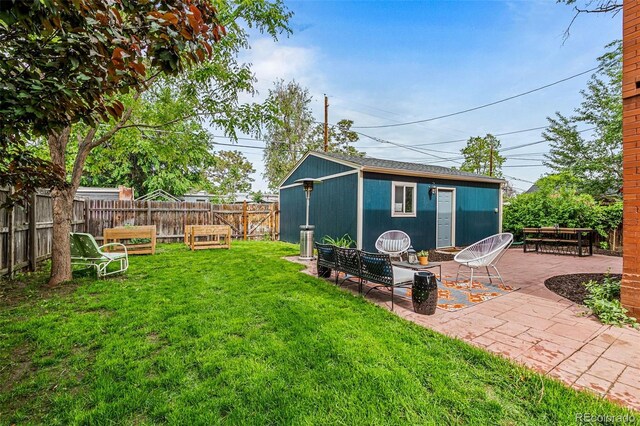 view of yard with a patio, a fenced backyard, and an outbuilding