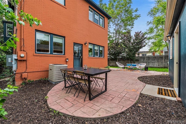 view of patio / terrace with central AC, outdoor dining space, and fence