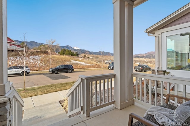 balcony featuring a mountain view and covered porch