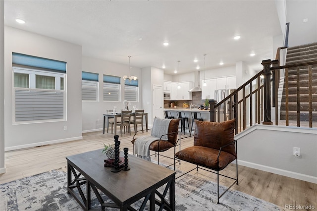 living room featuring a notable chandelier and light wood-type flooring