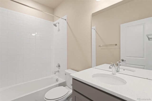 full bathroom with tiled shower / bath, vanity, and toilet