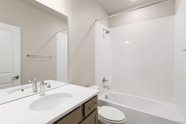 full bathroom with tiled shower / bath, vanity, and toilet