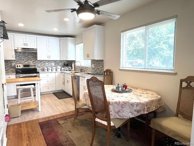 2285 S Knox Ct, Denver, CO 80219 - kitchen featuring stainless steel range with electric stovetop, a ceiling fan, light wood-style floors, light countertops, and decorative backsplash