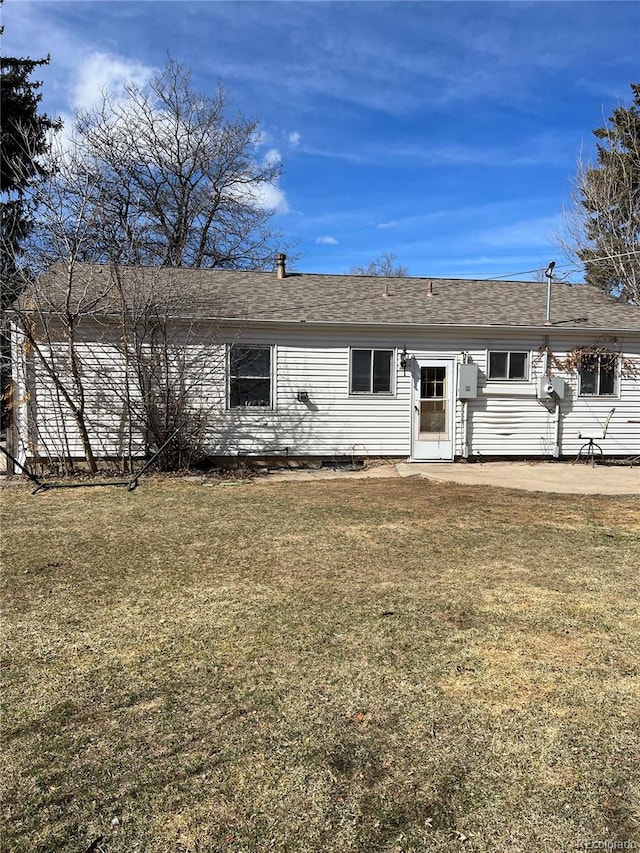 rear view of house featuring a lawn