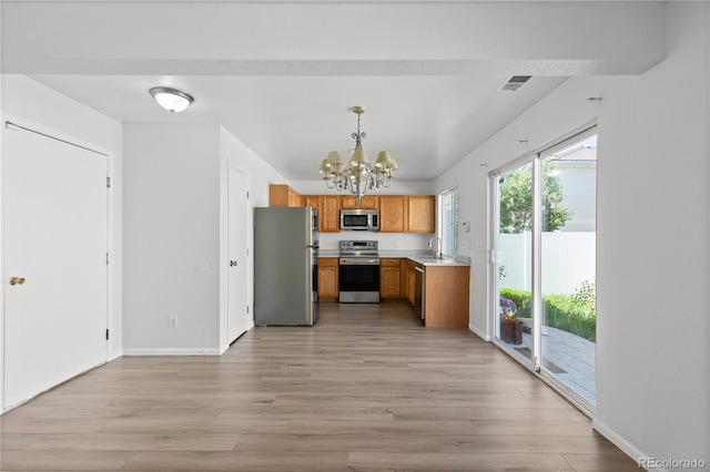 19817 E 47th Pl, Denver, CO 80249 - kitchen with appliances with stainless steel finishes, a chandelier, light countertops, and light wood-style flooring