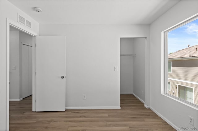 19817 E 47th Pl, Denver, CO 80249 - unfurnished bedroom featuring a spacious closet, wood finished floors, a closet, and baseboards