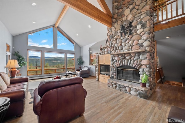 living area with a fireplace, beamed ceiling, light wood-style floors, baseboard heating, and high vaulted ceiling