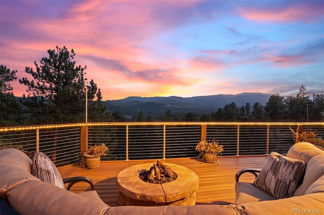 wooden terrace with a mountain view and an outdoor fire pit