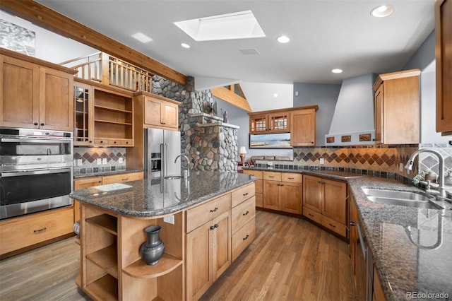 kitchen featuring open shelves, a sink, appliances with stainless steel finishes, and backsplash