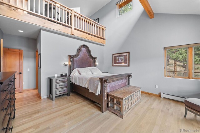 bedroom featuring baseboard heating, beam ceiling, high vaulted ceiling, baseboards, and wood finished floors