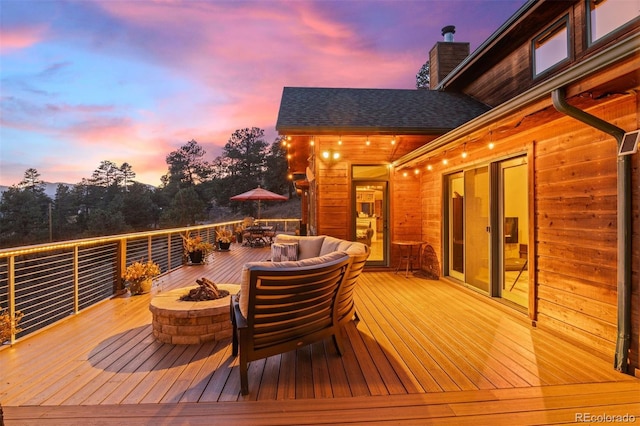 deck at dusk with a fire pit