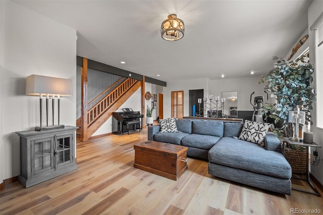 living area with stairway, a wood stove, recessed lighting, and wood finished floors