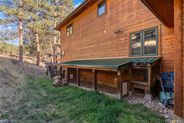 rear view of house with an outdoor structure, exterior structure, a standing seam roof, and metal roof