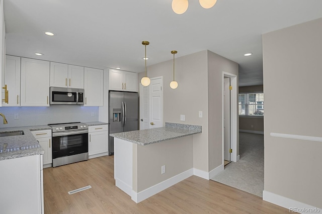 kitchen featuring kitchen peninsula, white cabinetry, light hardwood / wood-style flooring, and stainless steel appliances