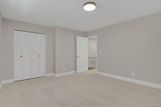 unfurnished bedroom featuring a closet and light colored carpet