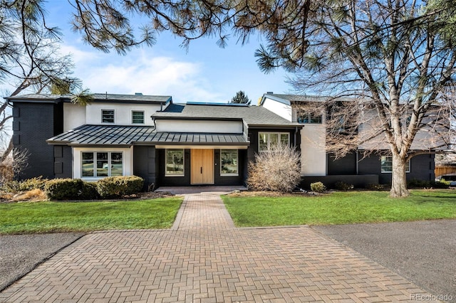 view of front of home featuring a front yard, a standing seam roof, and metal roof