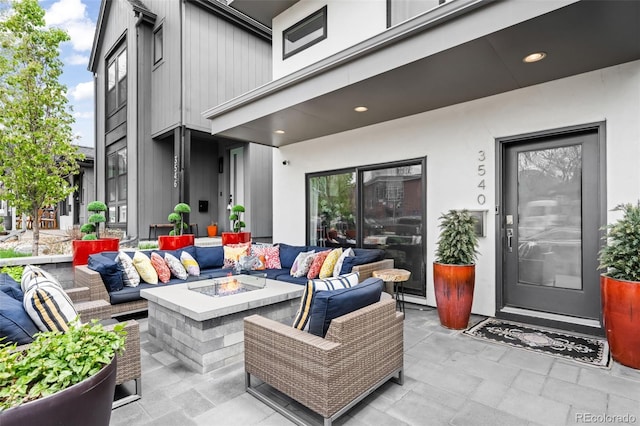 view of patio with an outdoor living space with a fire pit