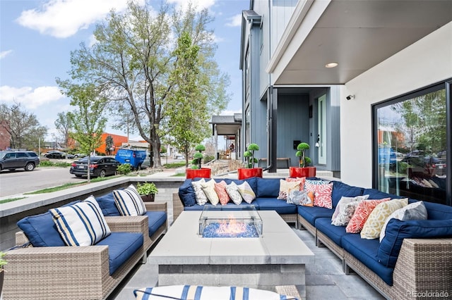 view of patio with an outdoor living space with a fire pit