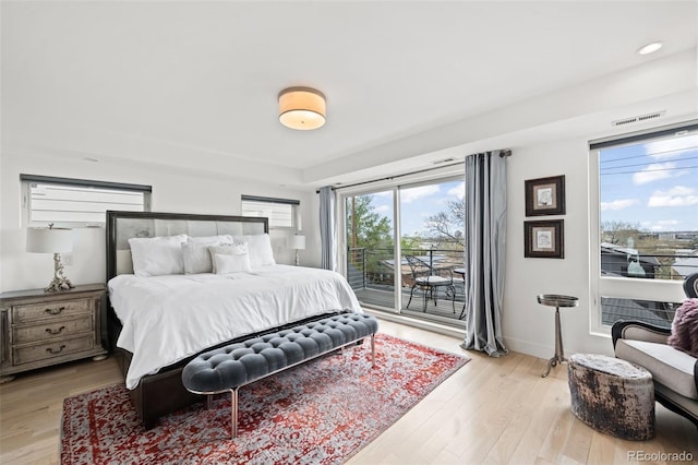 bedroom featuring baseboards, access to outside, light wood finished floors, and visible vents
