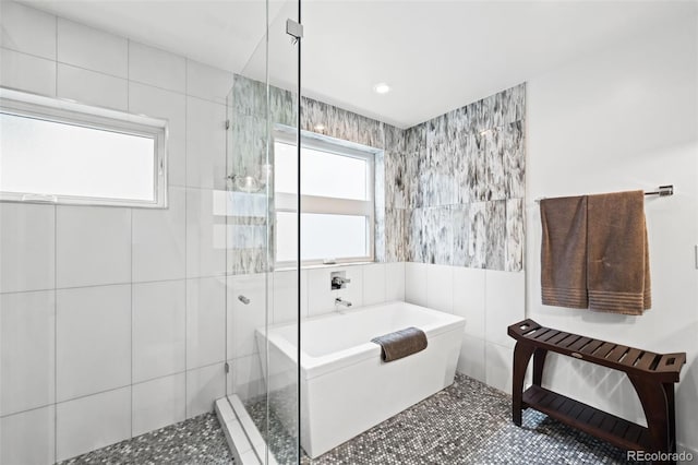 full bathroom with tile walls, tile patterned floors, a shower stall, and a freestanding bath