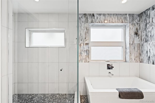 bathroom with a bath, tiled shower, recessed lighting, and plenty of natural light