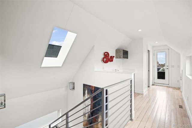 bonus room featuring light wood finished floors, lofted ceiling with skylight, baseboards, visible vents, and recessed lighting