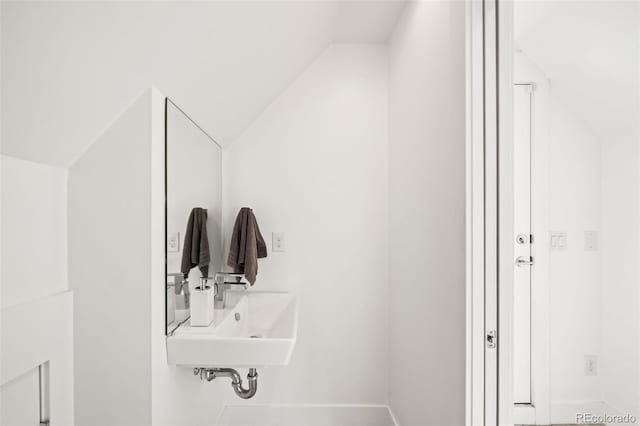 bathroom featuring vaulted ceiling and a sink