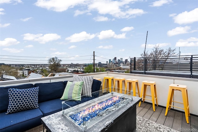 wooden deck featuring a fire pit, outdoor dry bar, and a view of city