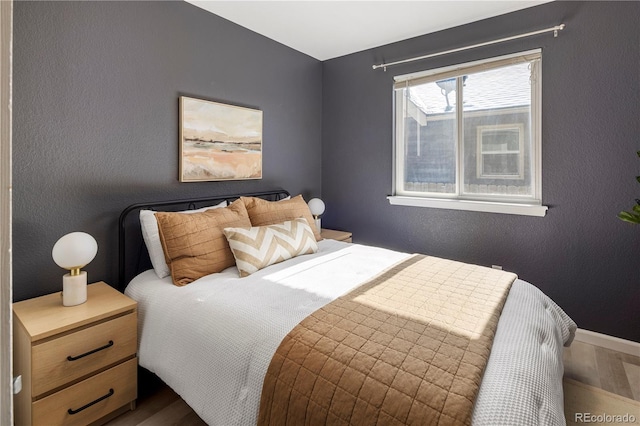 bedroom featuring a textured wall and wood finished floors