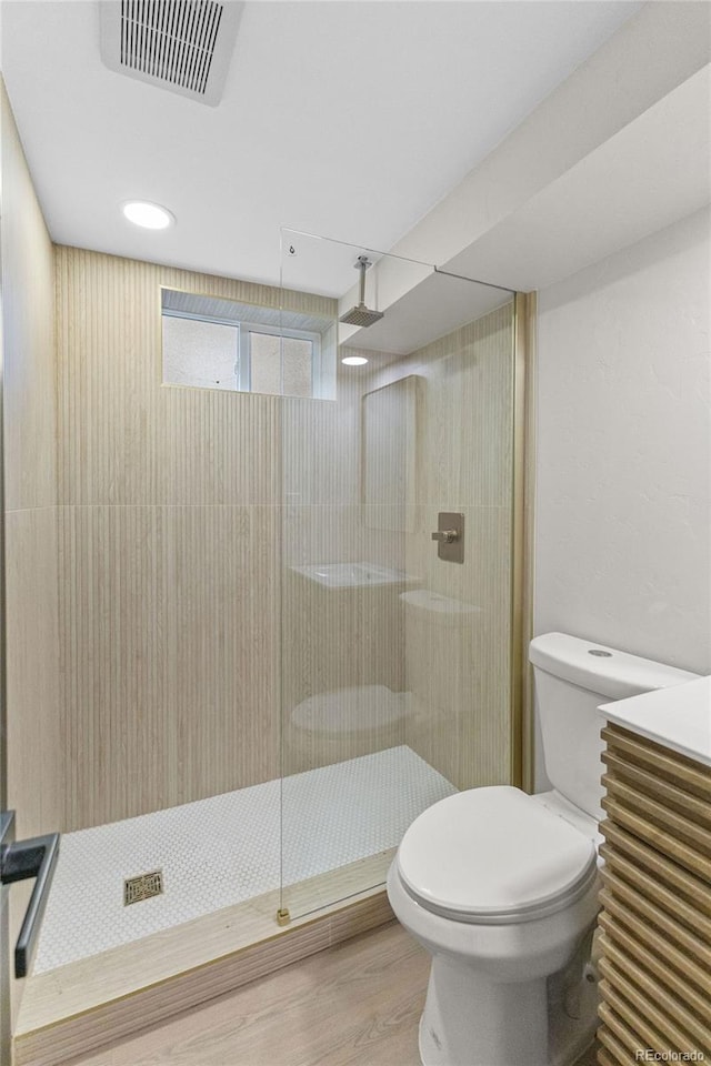 4580 Garland St, Wheat Ridge, CO 80033 - full bathroom with toilet, tiled shower, and wood finished floors
