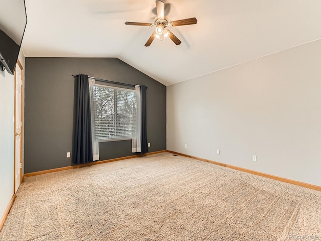 unfurnished room with a ceiling fan, carpet floors, vaulted ceiling, and baseboards
