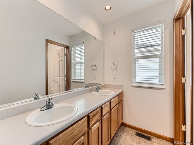 full bathroom with baseboards, double vanity, and recessed lighting