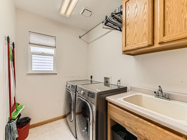 clothes washing area with cabinet space, washer and clothes dryer, baseboards, and light floors