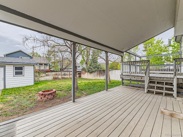 deck with an outdoor fire pit and an outbuilding