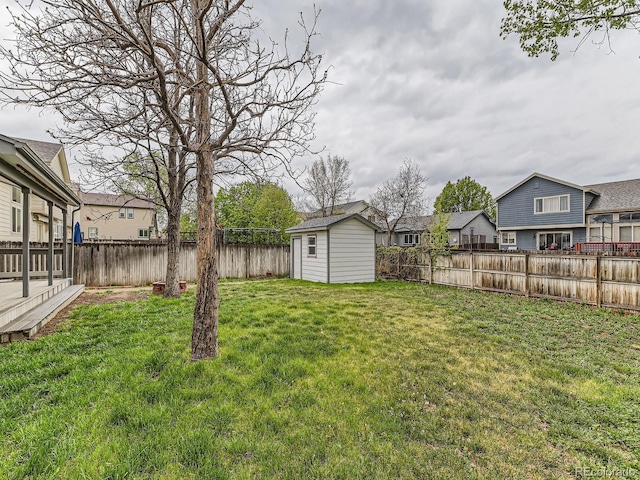 view of yard with an outdoor structure, a shed, and a residential view