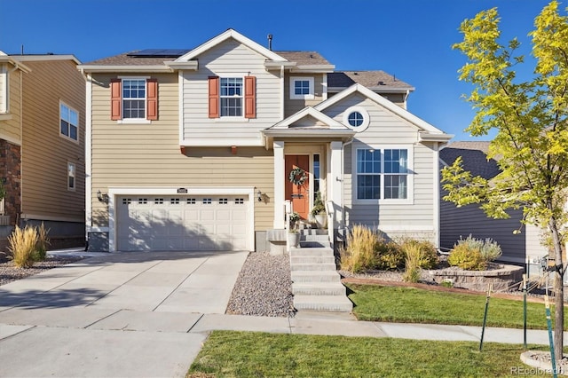traditional-style home featuring concrete driveway, solar panels, and a garage