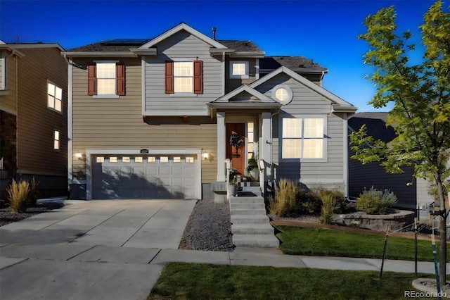 view of front of home with a garage, solar panels, and driveway