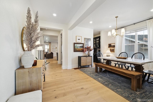dining space with light wood-type flooring, recessed lighting, baseboards, and an inviting chandelier