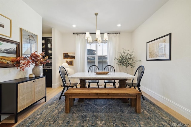 dining room featuring recessed lighting, baseboards, an inviting chandelier, and light wood finished floors