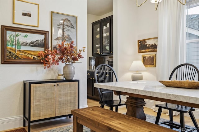 dining space featuring baseboards and light wood-style floors