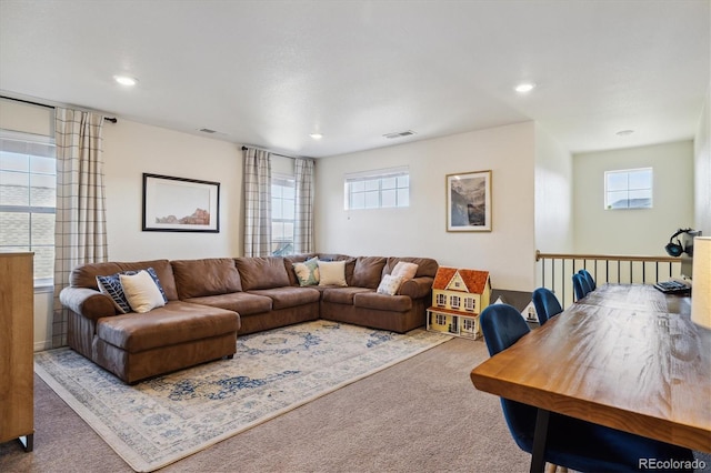 carpeted living room featuring visible vents, recessed lighting, and a wealth of natural light