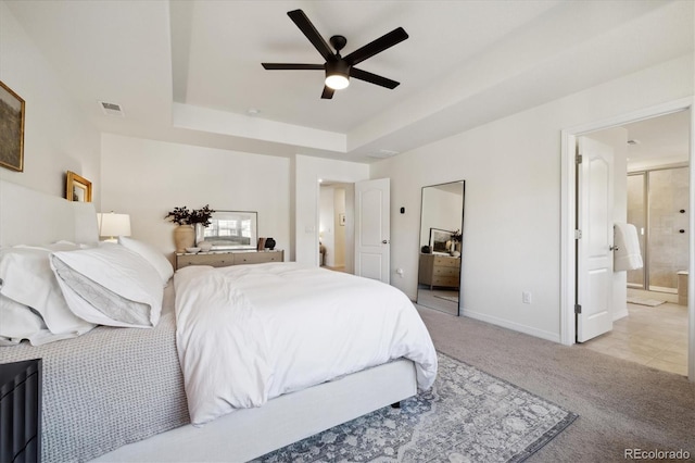 bedroom with ceiling fan, visible vents, a raised ceiling, baseboards, and light carpet
