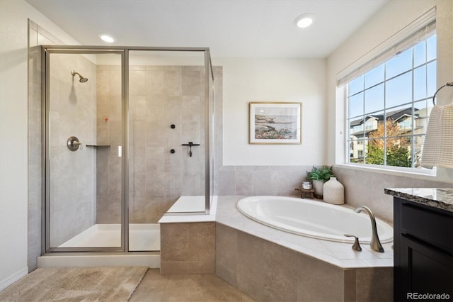 bathroom featuring vanity, tile patterned floors, a bath, and a stall shower