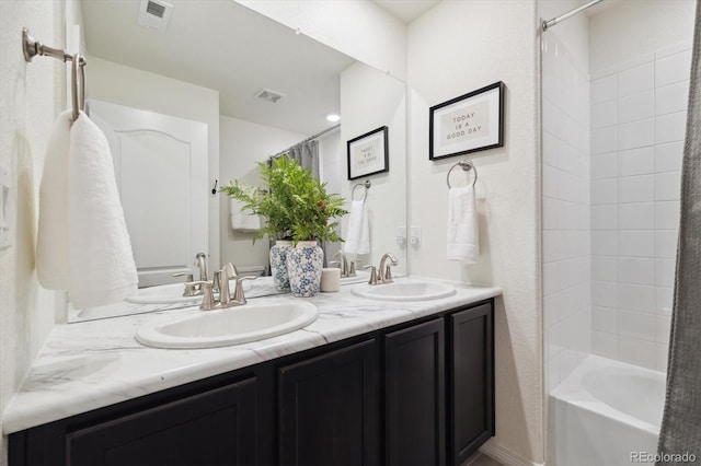 full bath featuring a sink, double vanity, and visible vents