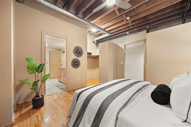 bedroom featuring ensuite bath and light wood-style flooring