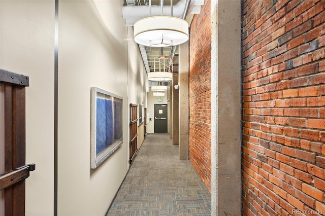 hallway with a high ceiling and brick wall