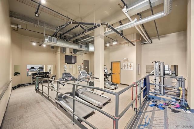 gym featuring electric panel, visible vents, and a high ceiling