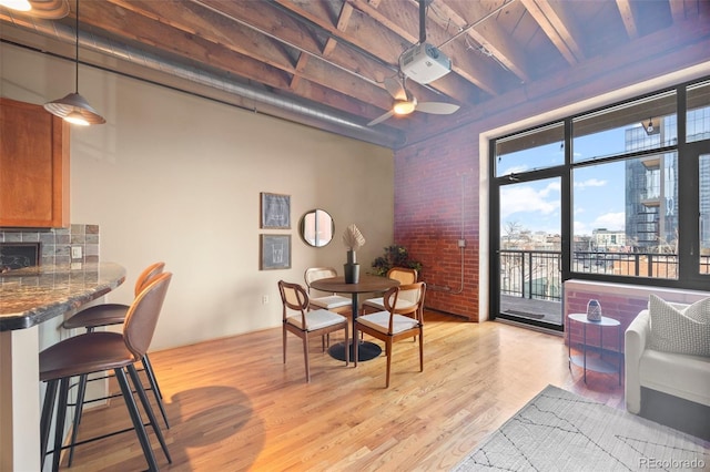 1800 Lawrence St Unit 303, Denver, CO 80202 - dining space featuring brick wall, light wood-style flooring, and a ceiling fan