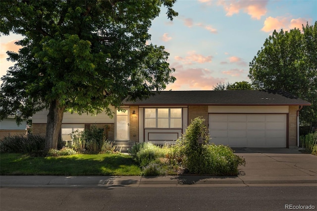 3176 S Alton Ct, Denver, CO 80231 - view of front of property with concrete driveway, an attached garage, and brick siding